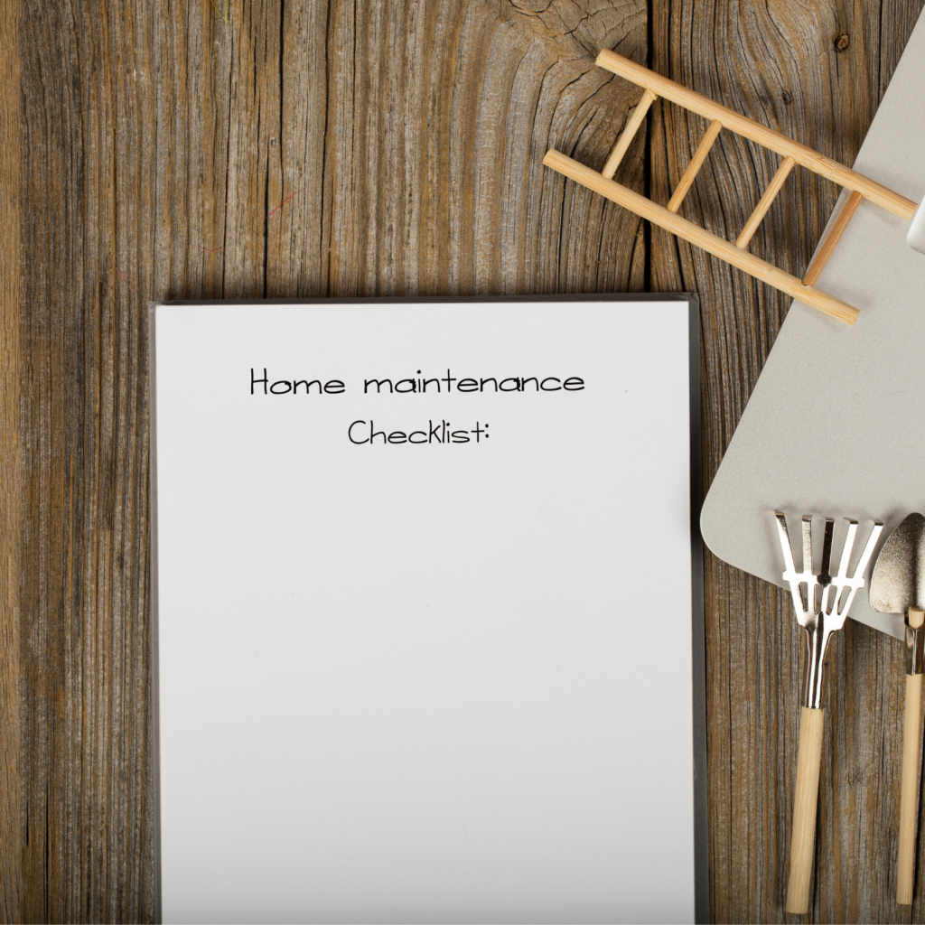 Notepad that says home maintenance checklist, with a small decorative wooden ladder and wooden lawn tools.