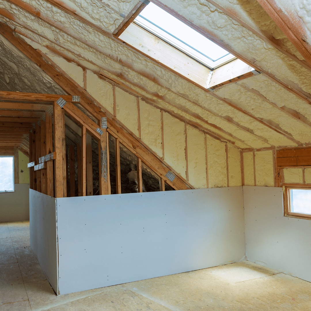 Close up frame of fiberglass insulation and wooden support beams in an unfinished attic space highlighting the importance of proper insulation installation for energy efficiency.